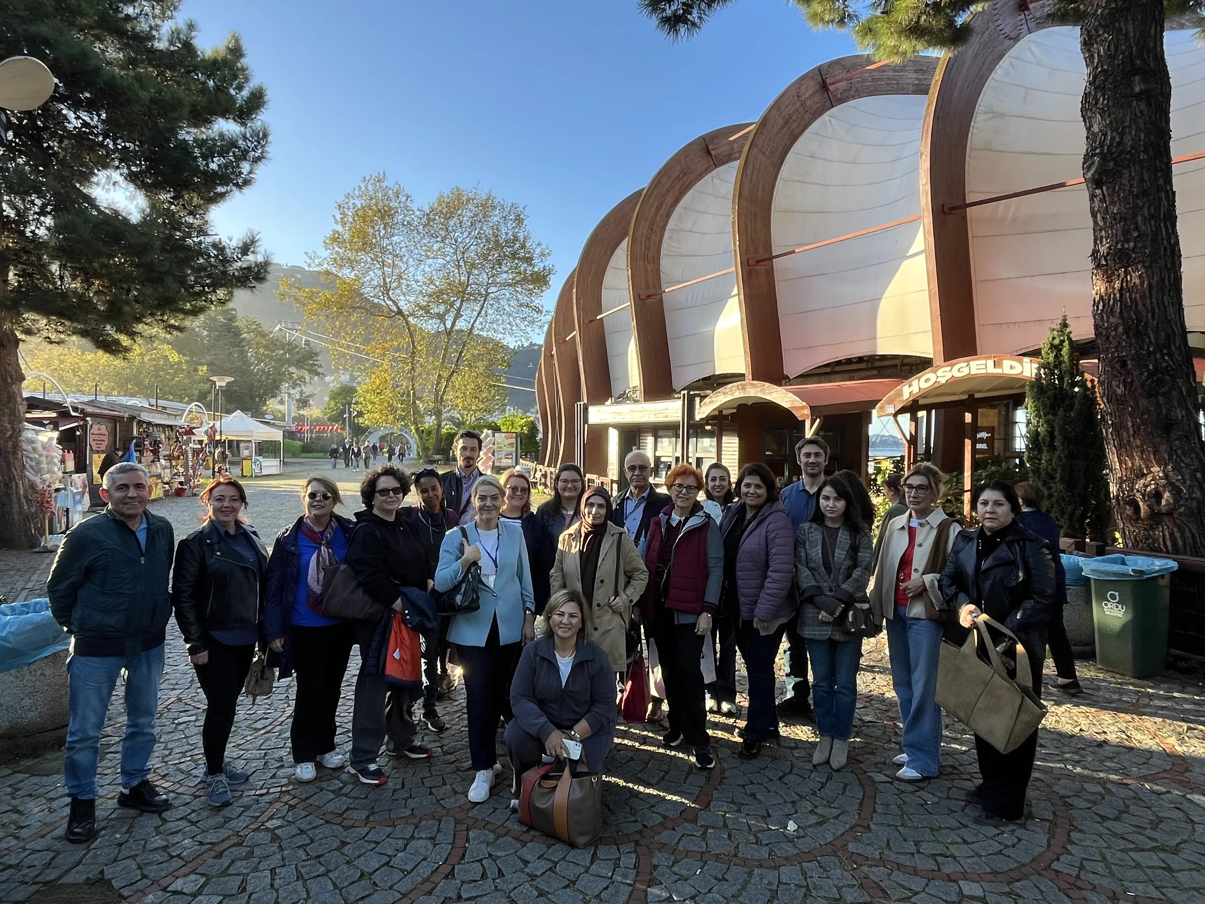 The group outside a waterfront building with a welcome sign